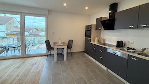 Una cucina moderna con zona pranzo, ampie finestre e vista sul quartiere.