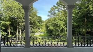 A covered outdoor area with columns and a view of a green landscape. - Liselund Ny Slot (Borre)