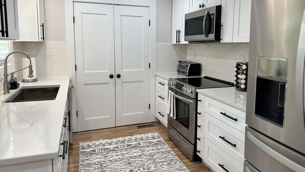 A modern kitchen with white cabinets, a stainless steel refrigerator, a microwave, an oven, and a sink. - 3 bedroom House in Campobello fits 8 people  (Campobello)