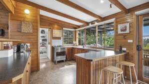 Una cucina moderna con pareti in legno, una grande finestra e un angolo bar.