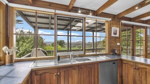 Cucina con un'ampia finestra, mobili in legno, lavello in acciaio inossidabile e lavastoviglie.