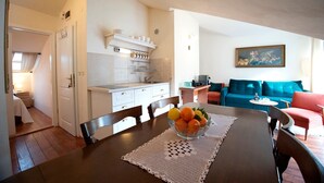 Un espace de vie compact comprenant une cuisine, un coin repas et un canapé.