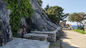 A stone pathway leading to a coastal building with a clear view of the sea. - One-Bedroom Apartment Senko A2 (Trpanj)