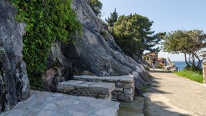 Un sendero de piedra que conduce a un edificio frente al mar, con vista despejada.