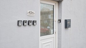 A white door with a glass panel, a flat mailbox, and a flat keypad device labeled 'Flat 3' to 'Flat 6' on the wall. - Private En-Suite Studio with TV, Fridge & Free Parking (Saint Thomas)