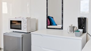 A compact kitchenette with a microwave, refrigerator, coffee maker, and a mirror. - Private En-Suite Studio with TV, Fridge & Free Parking (Saint Thomas)