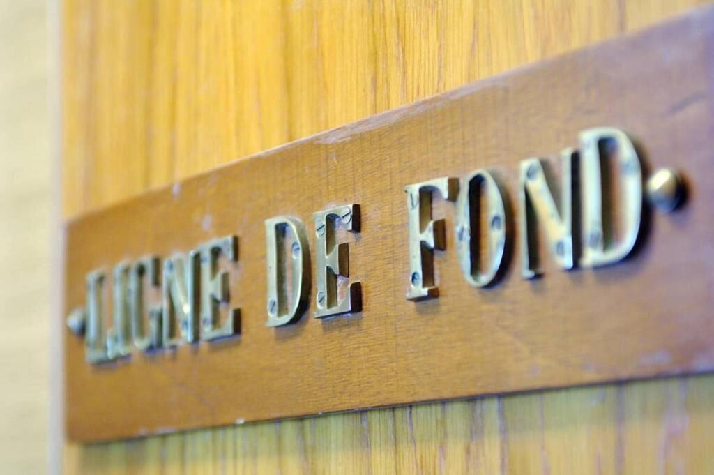 Une pancarte en bois portant l’inscription « LIGNE DE FOND ».