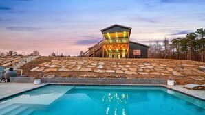 Un edificio moderno con piscina, escalones de piedra e una bandera.