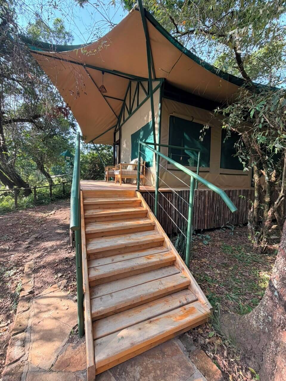 A wooden staircase leading to a covered outdoor area with a view of a building.