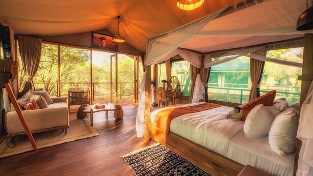 Una habitación amplia con una cama grande, un sofá, un escritorio y una silla.