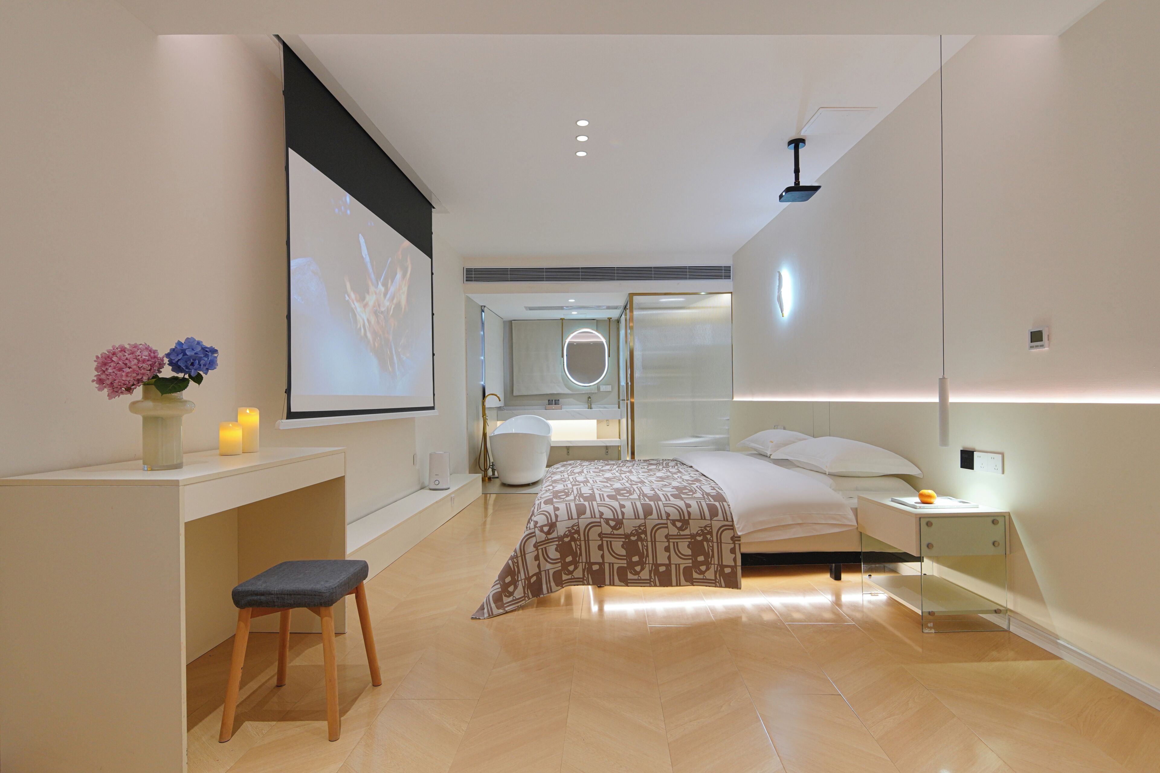 A modern bedroom with a bed, bedside table, and a desk with a chair.