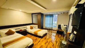 A hotel room with two beds, a TV, a coffee maker, and a window with curtains. - Hotel Dhaka Express (Kathmandu)