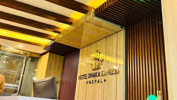 A reception area with a wooden ceiling, a reception desk, and a sign for Hotel Dhaka Express in Nepal. - Hotel Dhaka Express (Kathmandu)