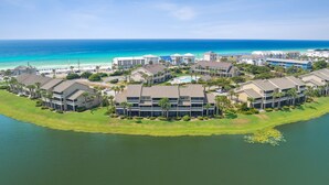 A coastal resort with multiple buildings, a swimming pool, and a view of the ocean. - Barefoot Bliss | Lakefront Villa Steps from Miramar Beach (Miramar Beach)
