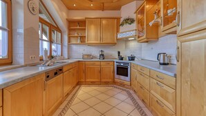 Una cocina con armarios de madera, horno empotrado y salpicadero de azulejos.