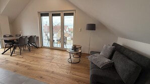 Un espacio tipo loft con comedor, sofá y una pequeña mesa.