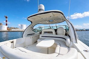 A boat with a covered cockpit, seating area, and a steering wheel. - Family Yacht Stay · Sleeps 6 · Pool, Gym & Beach (Key West)
