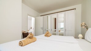 A hotel room with a bed, a wardrobe, a desk, and a lamp. - Apartment in Dramalj with balcony, sea view and pool (Crikvenica)