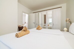 Ein Hotelzimmer mit Bett, Schrank, Schreibtisch und Lampe.