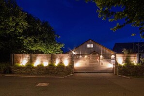 A modern house with a garage, surrounded by a stone wall and trees. - Beautiful 4 bedroom House in a peaceful village  nr Rock & Port Gaverne (Saint Endellion)