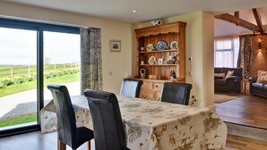Uma sala de jantar com uma mesa, cadeiras e um armário de madeira com pratos decorativos.