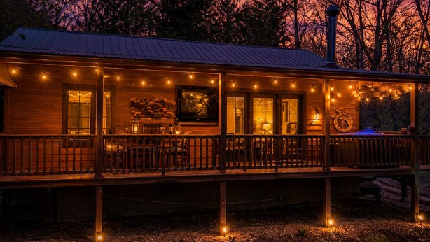 A wooden cabin with a porch, string lights, and a chimney. - Heart's Hideaway - Blue Ridge, GA (Morganton)