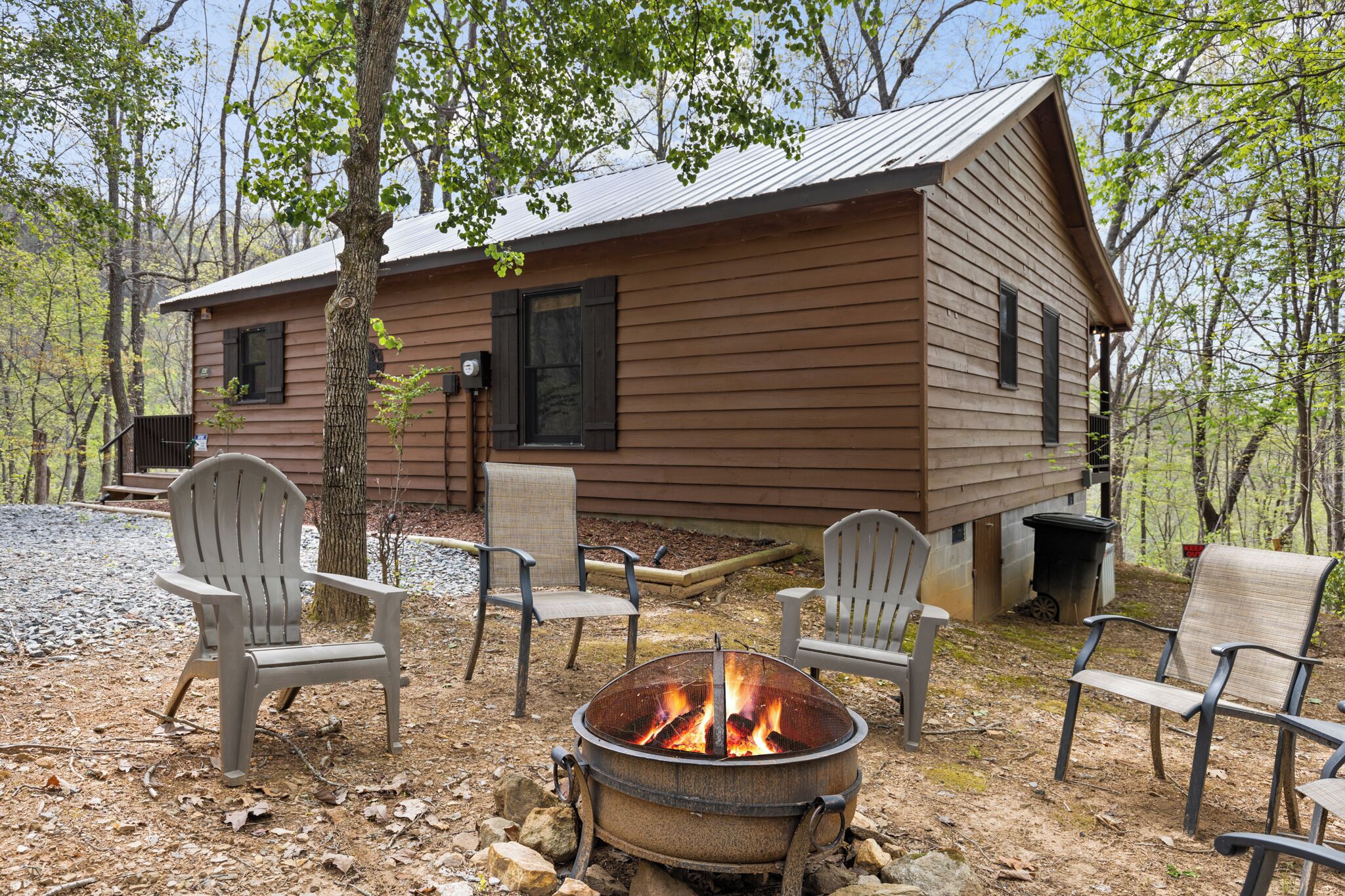 Une cabane avec un foyer et des sièges extérieurs.