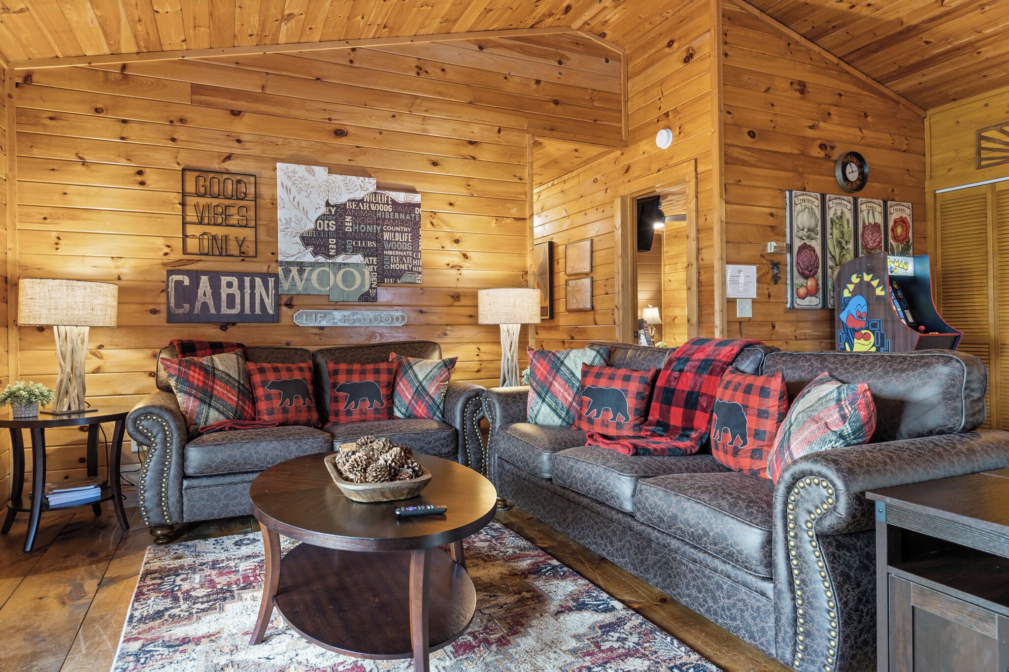 L'intérieur d'une cabine comprenant un ensemble de canapés, une table basse, une horloge et un mur orné de divers panneaux et tableaux.