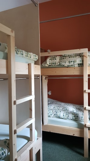 Ein Etagenbett mit Holzrahmen und einem unterem Bett mit Kissen in Punkteoptik.