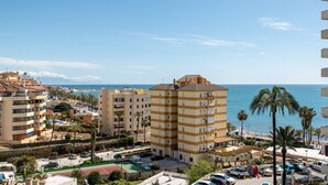 Eine Wohngegend an der Küste mit mehrstöckigen Gebäuden, einem Parkplatz und Blick auf das Meer.
