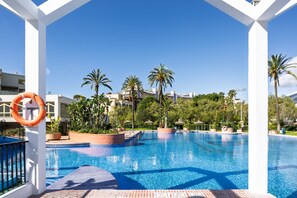 A clear blue pool with palm trees, a lifebuoy, and a white structure. - Rental BB 916-3 in Benalm Dena (Benalmádena)