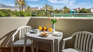 A balcony with a table set for breakfast, including orange juice, croissants, and a vase with flowers. - Rental BB 430-3 in Benalm Dena (Benalmádena)