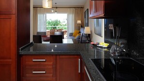 A modern kitchen with wooden cabinets, a granite countertop, and a black stovetop. - AS MM C08 in Mijas Costa (Mijas)