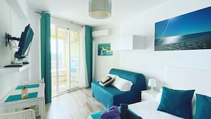 A hotel room with a bed, a desk, a chair, a TV, and a view of the sea. - Tamarindos 1002 in Benalm Dena (Benalmádena)