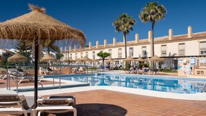 A pool area with lounge chairs, umbrellas, and palm trees. - AS MDS 112 in Mijas Costa (Mijas)