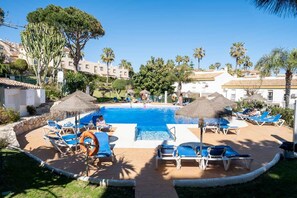 A pool area with lounge chairs, umbrellas, and a clear blue pool. - AS MD 3C3 in Mijas Costa (Mijas)