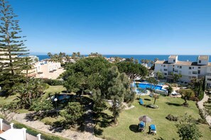Un resort con piscina, vegetación y vistas al mar.