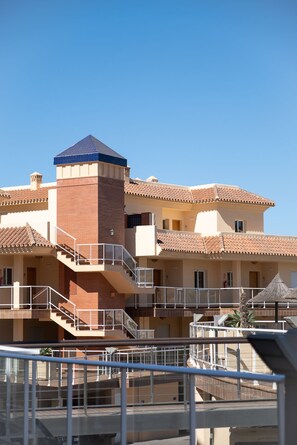 Un hotel de varios pisos con una torre central, balcones y una escalera.
