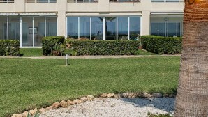 Ein mehrstöckiges Hotel mit Balkonen, großen Fenstern und einem gepflegten Rasen.