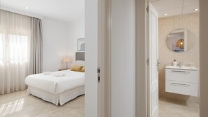 A hotel room with a bed, a bedside table, a lamp, and a bathroom with a sink and mirror. - AS MDM 5 in Mijas Costa (Mijas)