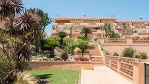 A hotel with a terraced garden, palm trees, and a clear blue sky. - AS EXT AL 2B1 3 1 in Mijas Costa (Mijas)