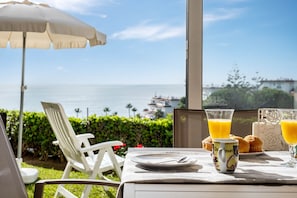 A table with breakfast items, a chair, and an umbrella overlooking the sea. - AS MDS 133 in Mijas Costa (Mijas)