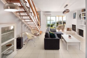 A modern living room with a staircase, a sofa, a coffee table, and a fireplace. - AS MDS 133 in Mijas Costa (Mijas)