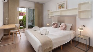 A modern hotel room with a large bed, a desk, and a chair, a balcony with a view, and a small table with a lamp. - AS EXT CBP Samisol FI 2 (Marbella)