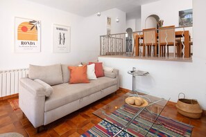 A living room with a sofa, a glass coffee table, a patterned rug, and a dining area with chairs and a table. - AS EXT CBP Samisol FI 2 (Marbella)