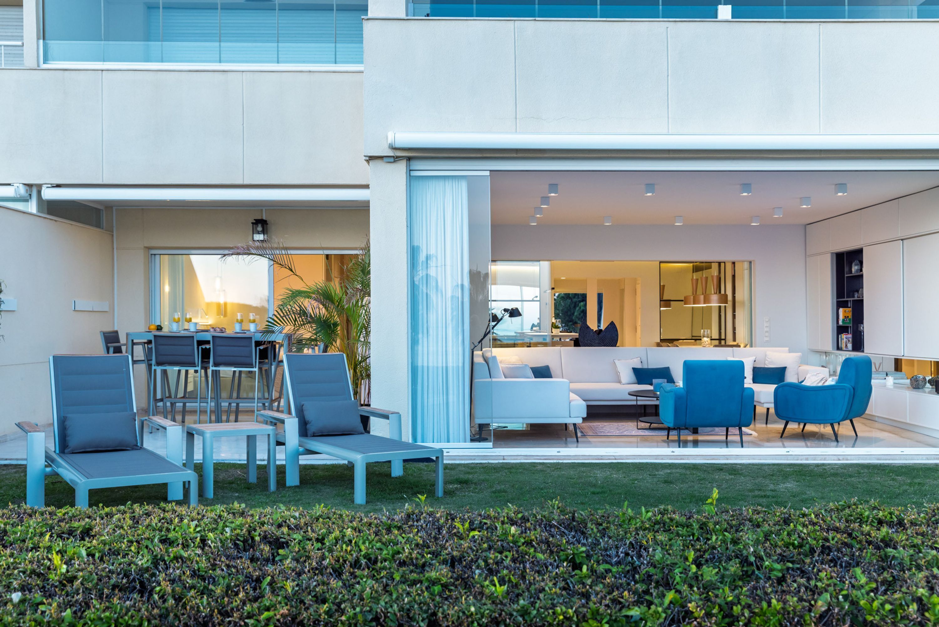 A modern outdoor living area with a patio, seating, and a view into the house.