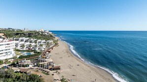 A coastal cityscape with a beach, buildings, and a clear sky. - AS EXT CBP Granados 1201 (Mijas)