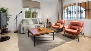 A modern living room with a sofa, two armchairs, a coffee table, a floor lamp, and a TV stand with a plant. - AS MDM 3 in Mijas Costa (Mijas)