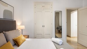 A hotel room with a bed, a nightstand, a lamp, a wardrobe, and a mirror. - AS MDM 3 in Mijas Costa (Mijas)