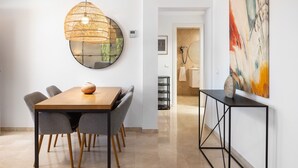 A modern dining area with a round mirror, a wooden table, and grey chairs. - AS MDM 3 in Mijas Costa (Mijas)